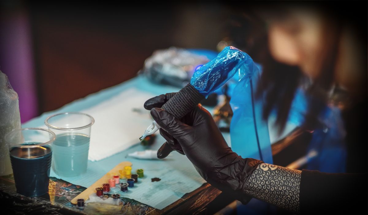 A tattoo artist preparing their workspace with ink and needles, emphasizing the importance of a sterile environment for a safe tattooing experience.